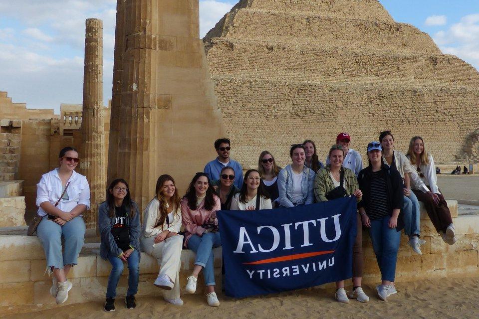 Students hold up a 利记sbo banner at Saqqara during a January 2023 trip to 埃及.